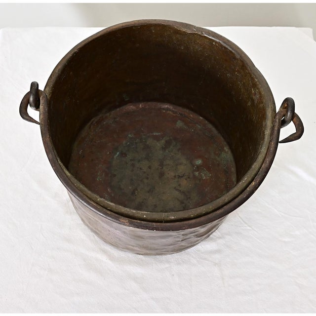 An antique French brass cooking pot with handle for suspending over the fire, dating to the second half of the 19th...