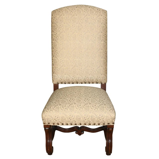 A vintage pair of Jacobean walnut tall side chairs with carved scroll legs and stretcher and upholstered in a gold painted...