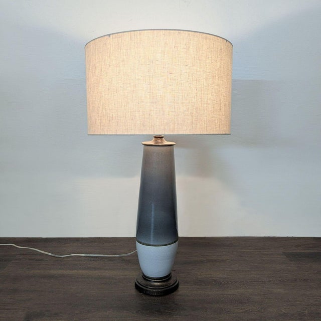 This Currey & Company table lamp features a sleek ceramic base with a gray and white gradient finish and a sturdy round...