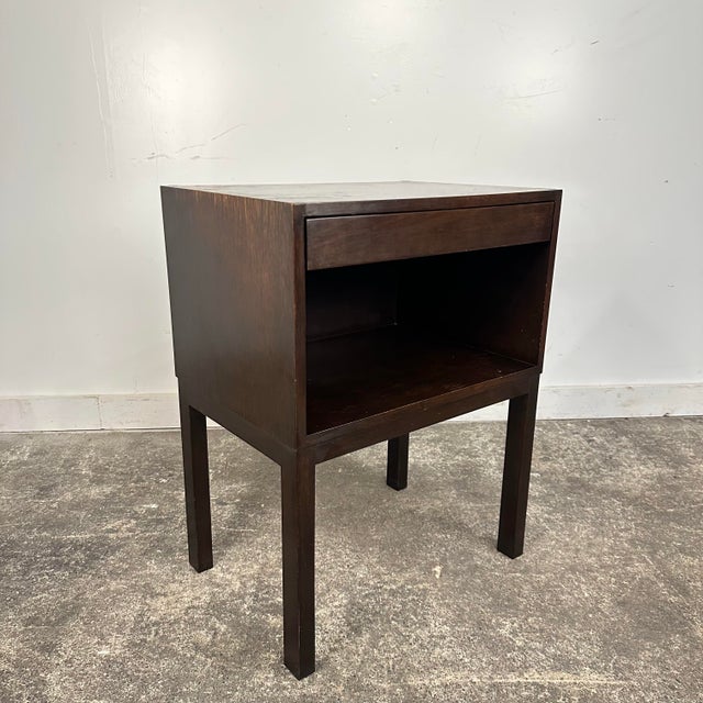 Edward Wormley for Dunbar nightstand in a dark walnut finish. This piece has a pull out drawer and open storage space...