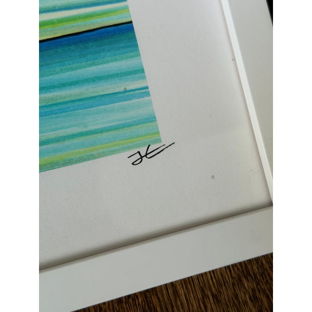 Contemporary framed art print featuring an abstract watercolor-style composition with layered horizontal bands in blue,...