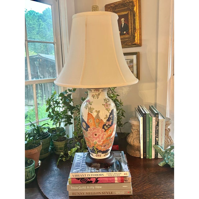 This is a vintage Chinoiserie Tobacco Leaf porcelain table lamp, richly decorated with hand-painted florals in a soft yet...