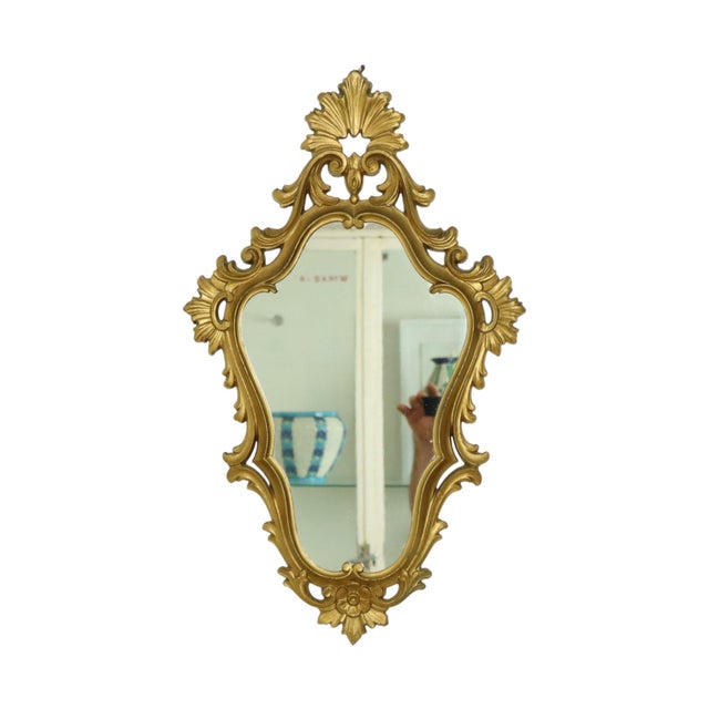 Italian classic crested mirror made of a gold-colored resin frame, entirely in Baroque or Rococo style, circa 1970s. This...
