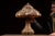 Table lamp featuring a domed shade constructed from an array of natural seashells set into a sand-textured matrix,...