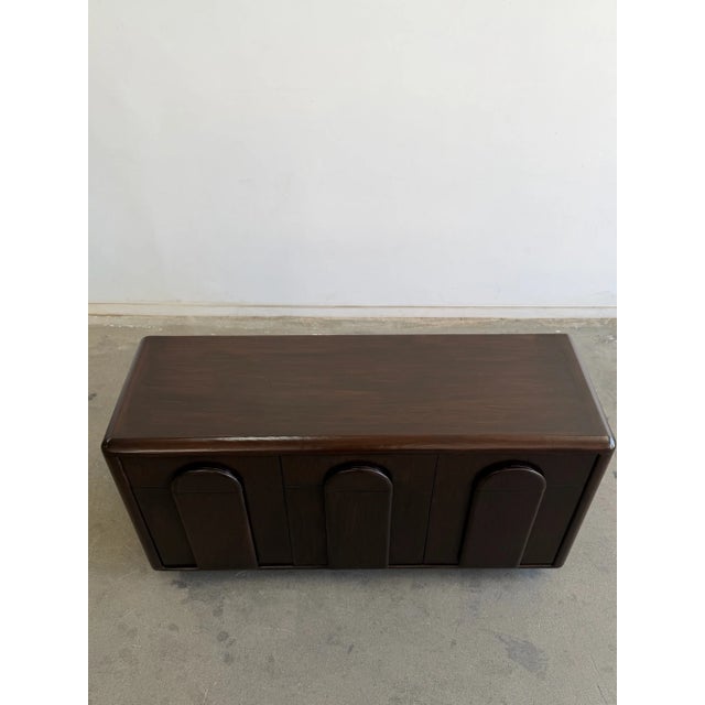 W56 D18 H30 The Arcadia Walnut Dresser is a statement piece, featuring sculpted arch panel detailing a handcrafted...