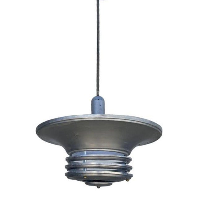 Striking 23" diameter Machine-Age pendant light features a spun aluminum shade with a streamlined saucer with 3 extended...