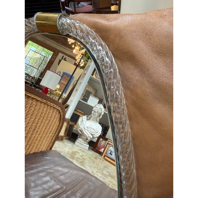 Elegant Murano wall mirror featuring a sculptural clear glass frame with a textured, rope-like pattern. Its softly tapered...