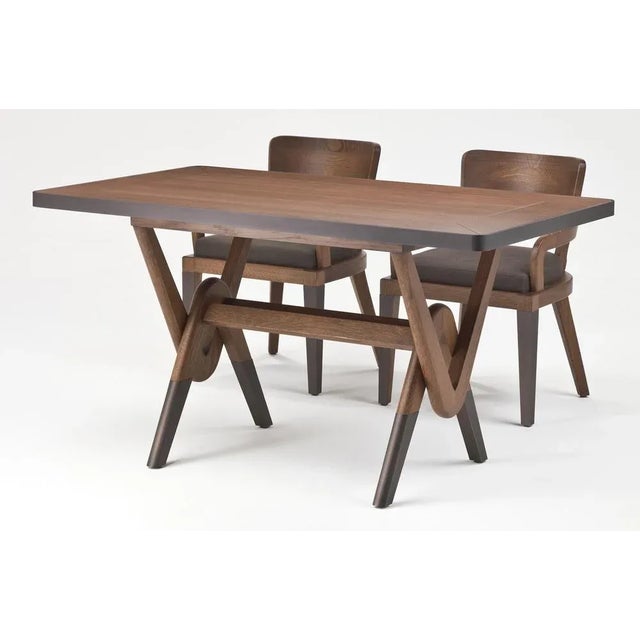 Wooden dining table in solid oak with dark bronzed metal details on feet