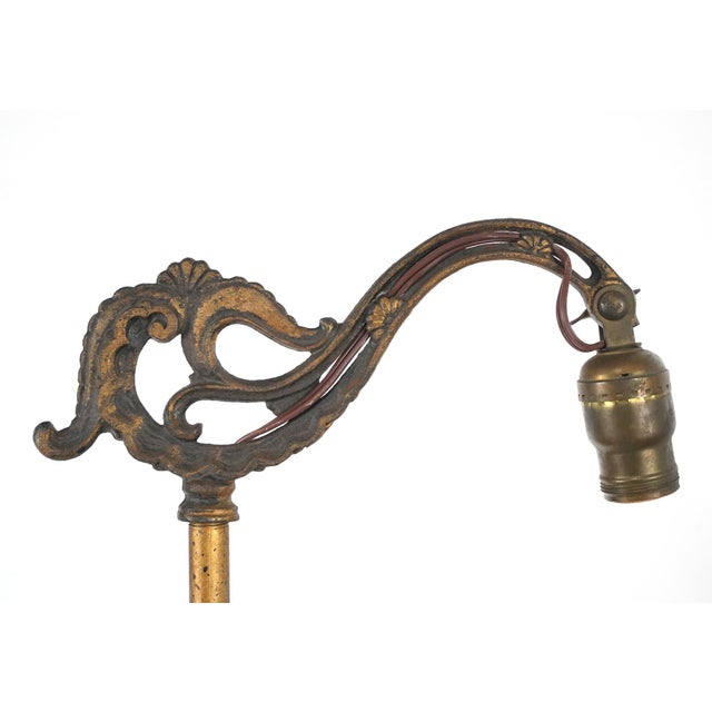 Art Nouveau style floor lamp with a bridge style arm, cast iron base, and brass pole and arm. This requires one standard...