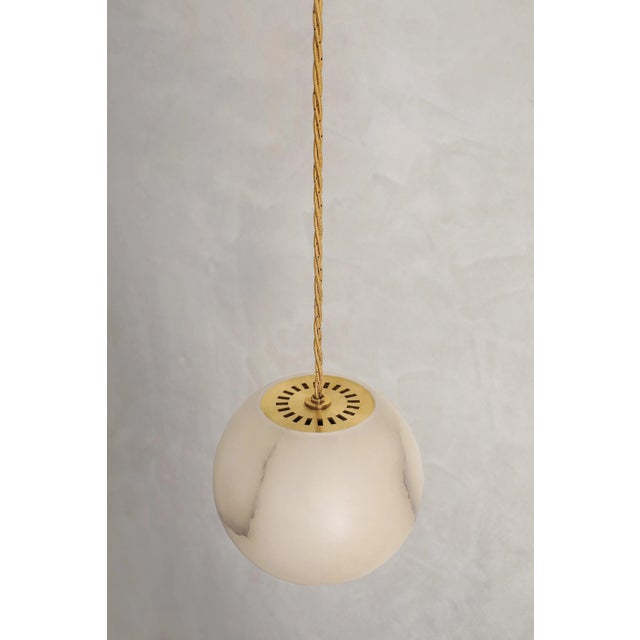 Planette cable 16.5 pendant by contain dimensions: ø 16.5 x h 100 cm (custom lenght). Materials: alabaster, brass, optical...