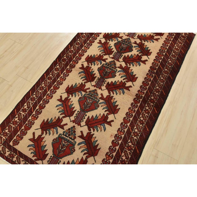 An authentic vintage tribal Baloch rug hand-knotted with fine wool and natural dyes. This nomadic oriental rug features a...