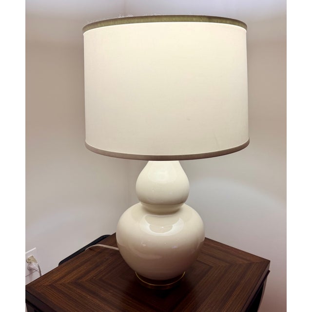 Elegant pair of Ethan Allen ceramic table lamps featuring a soft cream glaze and classic gourd silhouette on a brass base....