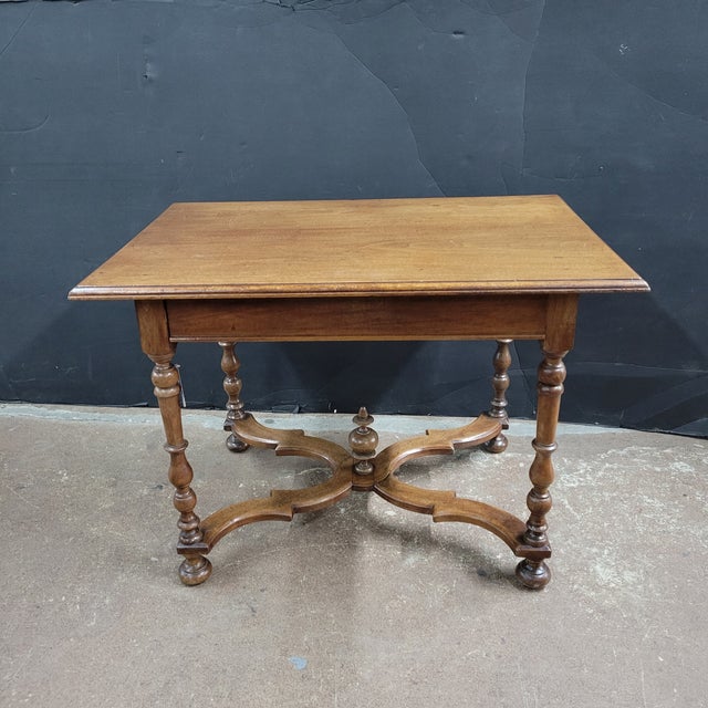 This French 19th Century Walnut Side Table With X-Stretcher, Turned Legs & a Drawer has such a pretty finish to it. The...