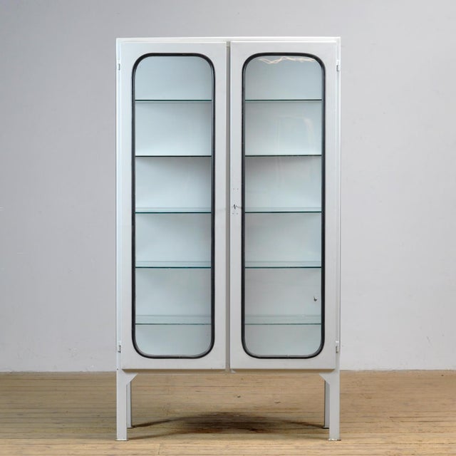Vintage medical cabinet from the 1970s, made in Hungary. This characterful cabinet is made of iron and glass, with the...