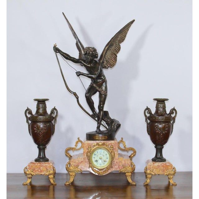 This exceptional antique French clock garniture showcases the beautifully sculpted “Amour Irresistible” angel statue,...
