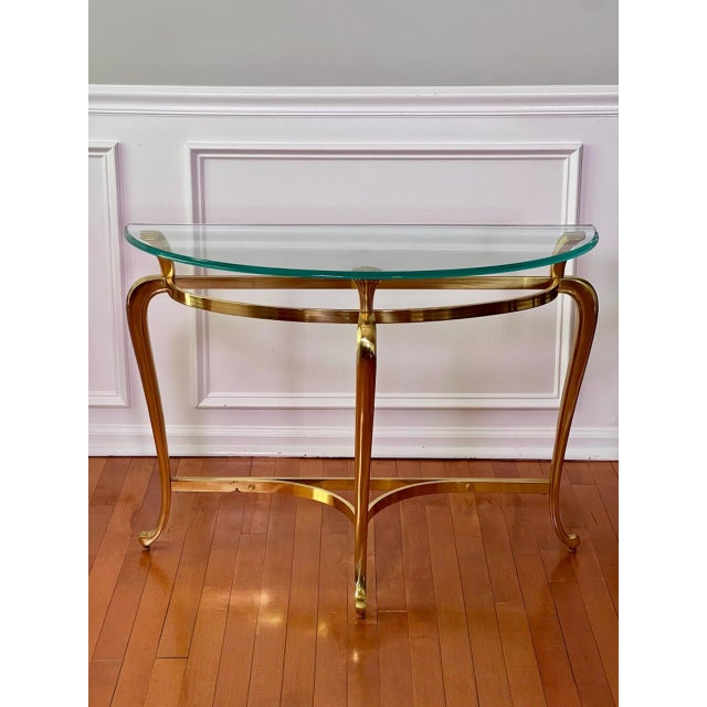 A vintage Maison Jansen Regency style demilune solid brass console table with a thick, ogee edge glass top. Very well made...