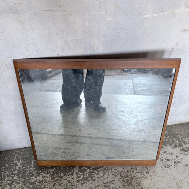 A beautifully understated mid-century teak mirror featuring a clean-lined rectangular frame with softly rounded corners...