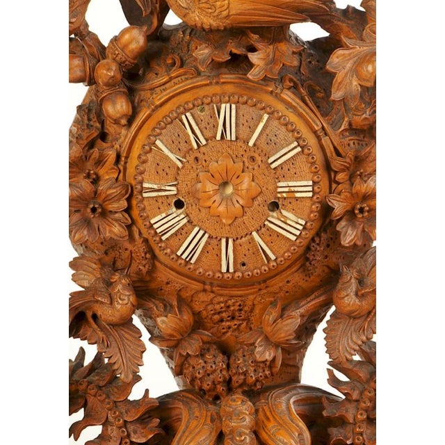 Continental, late 19th century, base with chain detail carving, highly decorated with flora, fauna and birds, clock face...
