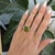 A large natural peridot from Arizona pours fresh lime-green light through this oval ring, encircled by a brilliant halo of...