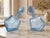 A striking pair of Mid-Century Modern sculptural art glass decanters crafted in a delicate light blue transparent glass....