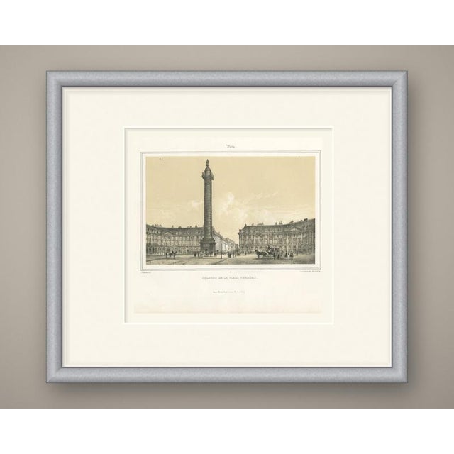 A tinted lithograph of the place vendome in paris, with its triumphal column rising high into a pale cream sky. The...