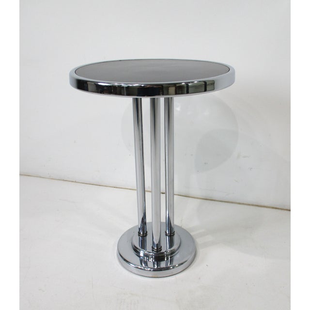 A smaller scale chromed side or cigarette table with round chrome banded black Formica top by the iconic Art Deco designer...