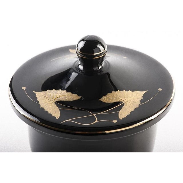 This black urn is a glossy black cup vase with lid and floral motive, realized in Germany between 1940s-1950s. In...