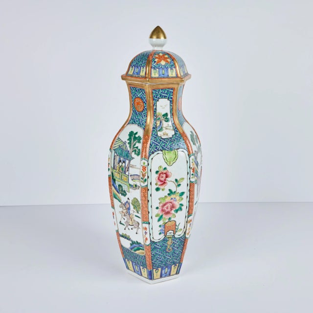 A pair of six sided, beautifully hand-painted covered porcelain vases featuring traditional figures and flowers, all...