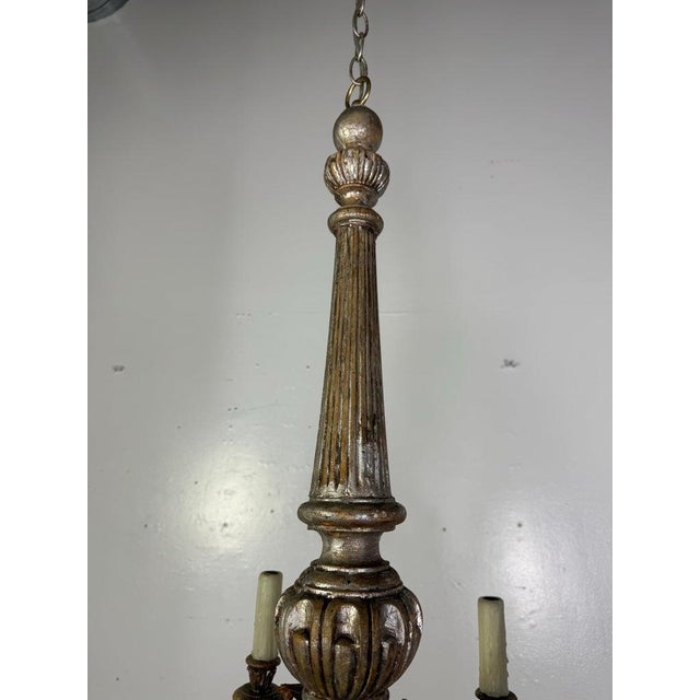 A beautifully aged Italian chandelier featuring a carved silvered wood central column with fluted and gadrooned details....