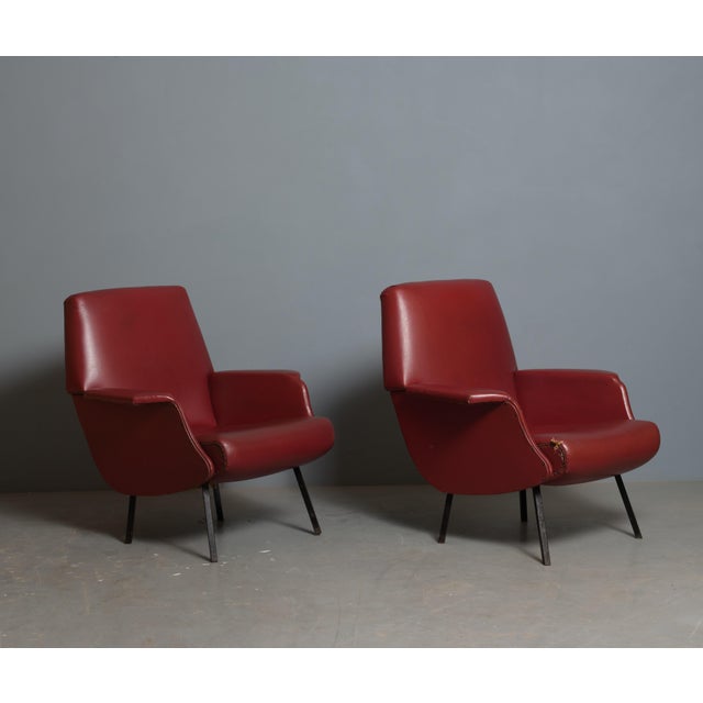 Pair of Italian armchairs dating from the 1950s, characterized by a compact and angular mid-century design. Each armchair...