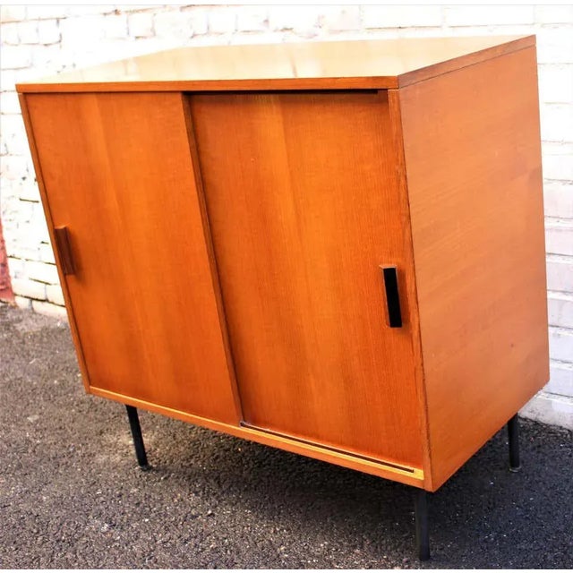 This cabinet by I.S.A Bergamo with sliding doors teak veneer metal legs, Italy, 1960s.