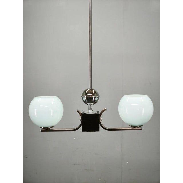 Original art deco chandelier produced in czechoslovakia during the 1930s. Crafted from chrome-plated metal with a...