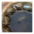 Vintage hand thrown studio pottery bowl featuring impressed circular motifs and a rich brown glaze with natural variations...