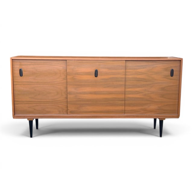 A beautifully restored Mid-Century Modern walnut credenza that showcases the clean lines, exceptional craftsmanship, and...