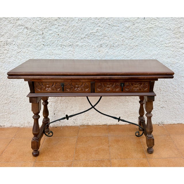 Beautiful Spanish drop-leaf table crafted from wood, featuring a traditional design with richly carved details and a...