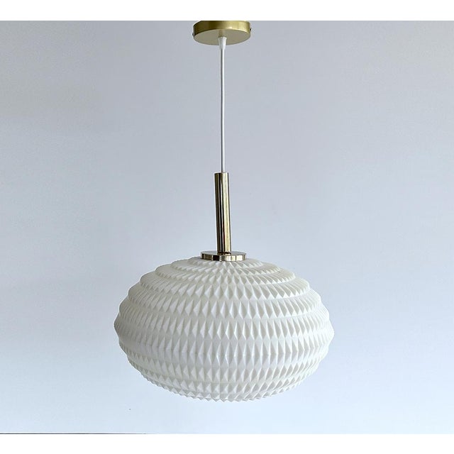 Mid century vintage cocoon pendant light with a flattened composite acrylic globe shade with diamond relief patterns and...