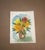 Original watercolor floral painting featuring a cheerful bouquet of golden yellow, coral, peach, and red blossoms arranged...