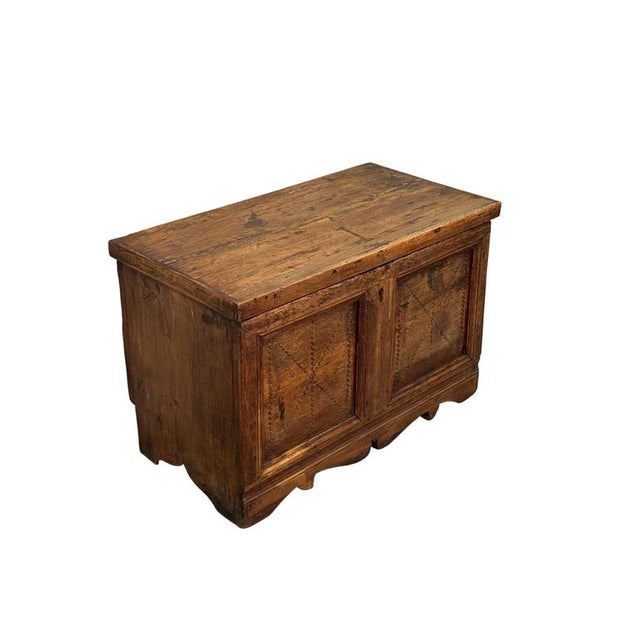 A 19th-century fir wood chest, characterized by a solid structure and a front embellished with panels and decorations that...