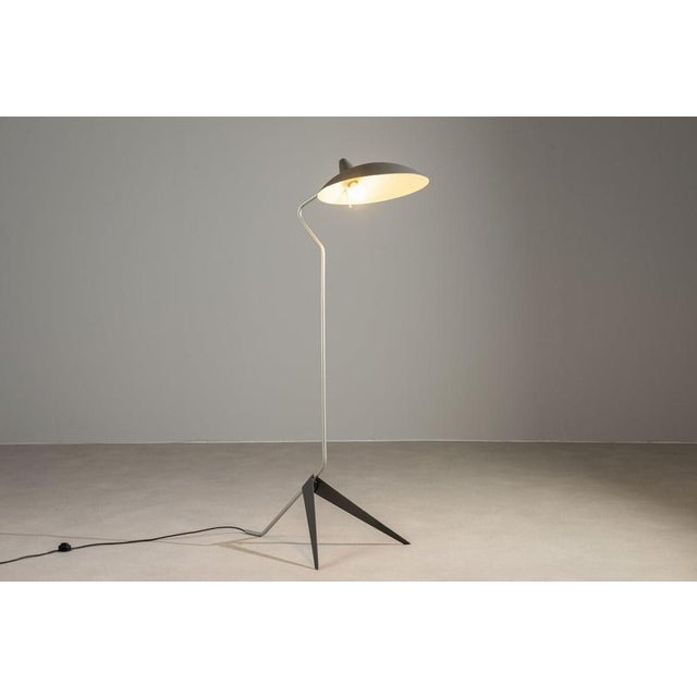 This striking Mid-Century floor lamp showcases an industrial French design from the 1980s, defined by its dynamic angled...