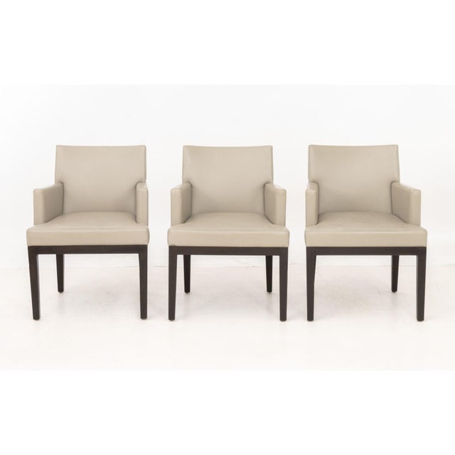 Set of Six Christian Liaigre Style Dining Armchairs, with taupe upholstery on wood legs. 33" H x 24.5" W x 25" D; seat:...