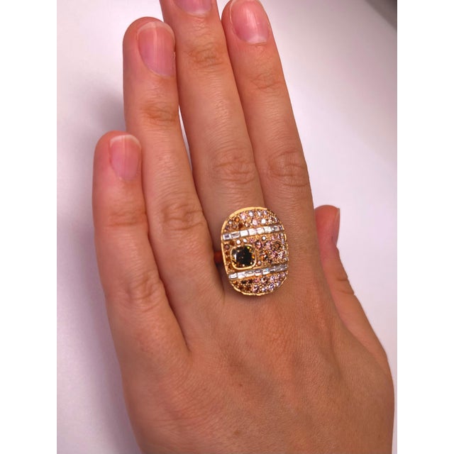 Oval design natural fancy earth tone diamond pave and two bands of channel set baguettes with a bezel set fancy brown...