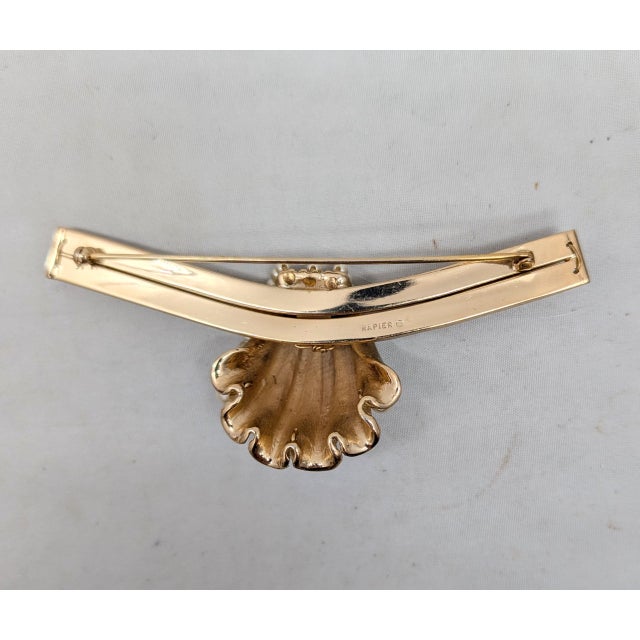 1950s goldtone matte shell center with lines of faux-pearls brooch with security clasp. Marked "NAPIER©" on the back....