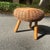 In the manner of Tony Paul, a three legged wicker stool with a wood base. Base is detached from top (that is how the piece...