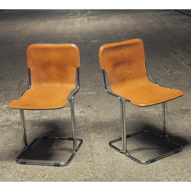 Pair of "Calla" dining chairs by Antonio Ari Colombo for Arflex, 1970s. Cognac saddle leather seat and back, white cotton...