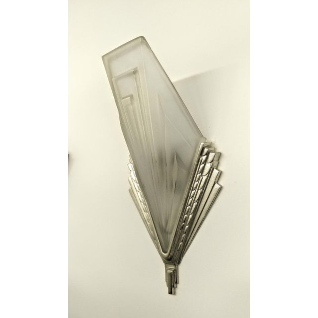 A pair of French Art Deco sconces by the French artist "Degue" in a molded clear frosted glass decorated with geometric...