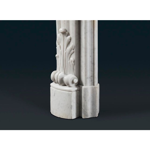 An antique French nineteenth-century Louis XV-style Rococo Carrara marble fireplace surround, the elaborately shaped and...