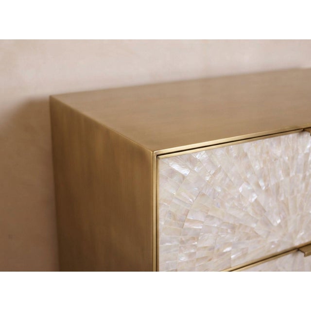 A luminous composition of natural mother-of-pearl and brushed brass, the Arcana Three-Drawer Nightstand brings intricate...