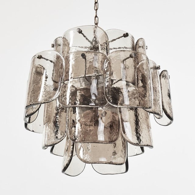 Vintage Murano glass chandelier featuring an elegant composition of hand-blown clear and smoky glass petals arranged...