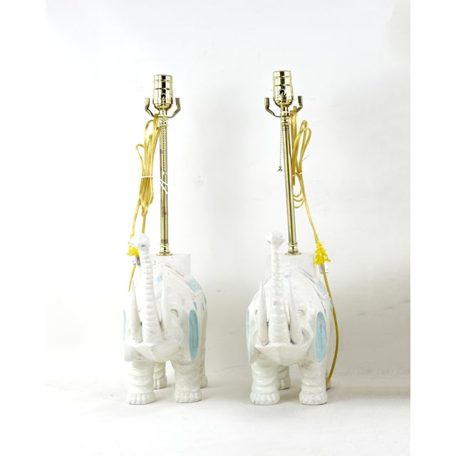 A pair of vintage white handmade wooden elephant table lamps