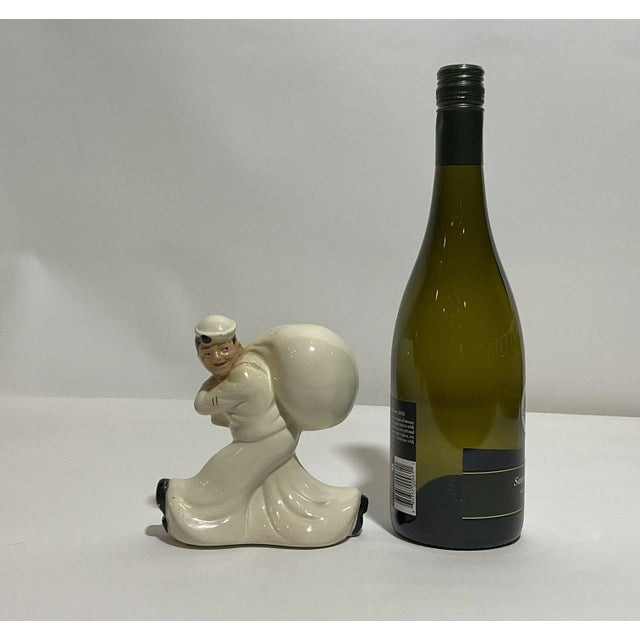 A sailor with duffel bag over his shoulder. Coin bank with stopper marked Seamens Bank for Savings. Dated 1960. Weight: 1...